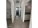 Tile hallway with visible laundry room and bathroom at 38085 W Excussare Way, Maricopa, AZ 85138