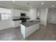 Bright kitchen with white cabinetry, stainless steel appliances, and granite countertops at 38085 W Excussare Way, Maricopa, AZ 85138