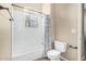 Bathroom with white tiled shower and bathtub combination, a window, and neutral paint at 3835 E Leland St, Mesa, AZ 85215