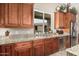 Well-lit kitchen featuring wood cabinetry, granite countertops, stainless steel appliances, and tile flooring at 3835 E Leland St, Mesa, AZ 85215