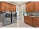 Laundry room equipped with modern washer and dryer, ample cabinetry, and tiled floor at 3835 E Leland St, Mesa, AZ 85215