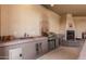 Outdoor kitchen featuring a built-in grill, sink, and fireplace at 3835 E Leland St, Mesa, AZ 85215