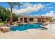 Beautiful backyard pool area with rock features and mature palm trees at 3835 E Leland St, Mesa, AZ 85215