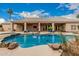 Backyard pool area features a rock waterfall, lush landscaping, and ample patio space at 3835 E Leland St, Mesa, AZ 85215