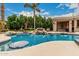 Backyard pool with rock waterfall feature, poolside bar, and beautiful landscaping at 3835 E Leland St, Mesa, AZ 85215