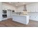 Bright kitchen with an island, white cabinets, stainless appliances, and wood-look tile flooring at 3909 E Gold Mountain Ave, San Tan Valley, AZ 85143