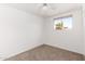 A simple bedroom featuring a window with a palm tree view and neutral carpet at 6414 W Osborn Rd, Phoenix, AZ 85033