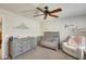 Bedroom featuring crib, dresser, and comfy armchair at 9131 W Albert Ln, Peoria, AZ 85382