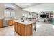 Open kitchen with island, granite countertops, and wood cabinets at 9131 W Albert Ln, Peoria, AZ 85382