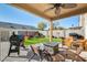 Covered patio with fire pit, grill, and seating at 9131 W Albert Ln, Peoria, AZ 85382