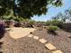Stone-paved patio with landscaped backyard featuring rocks, plants, and a tiered waterfall feature at 20436 N 17Th Pl, Phoenix, AZ 85024