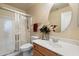 Bathroom with wood vanity, round mirror, floral accents and a glass enclosed shower at 20436 N 17Th Pl, Phoenix, AZ 85024