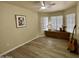Neutral living room featuring wood-look floors, ceiling fan, and natural lighting near the window at 20436 N 17Th Pl, Phoenix, AZ 85024