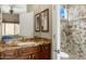 Bathroom with granite vanity, tiled shower, and large mirror at 34704 N 93Rd Pl, Scottsdale, AZ 85262