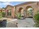 Lovely home exterior with arched entryway and gated courtyard at 34704 N 93Rd Pl, Scottsdale, AZ 85262