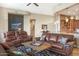 Spacious living room with leather sofas, a stone fireplace, and large windows at 34704 N 93Rd Pl, Scottsdale, AZ 85262