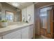 Bathroom showcasing a vanity with a sink, neutral tile, and a view into the shower at 37615 N Tranquil Trl, Carefree, AZ 85377