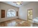 Bright bedroom featuring wood floors, ceiling fan, and an adjacent bathroom entrance at 37615 N Tranquil Trl, Carefree, AZ 85377