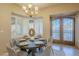 Bright dining room featuring elegant chandelier, bay window with shutters, and round table set for six at 37615 N Tranquil Trl, Carefree, AZ 85377