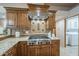 Gas stovetop, stainless vent hood and granite countertops in this updated kitchen at 37615 N Tranquil Trl, Carefree, AZ 85377