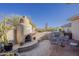 Charming outdoor patio featuring a stucco fireplace, built-in grill, and stone flooring at 37615 N Tranquil Trl, Carefree, AZ 85377