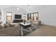 Spacious living room with sleek furniture, a large TV, and a sliding glass door leading to the outdoors at 42140 N Golden Trl, San Tan Valley, AZ 85140