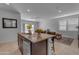 Kitchen island with seating, offering an open view of the living area at 1057 W Chimes Tower Dr, Casa Grande, AZ 85122