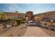 Desert landscape surrounds this single-story home with a circular drive at 11461 S Wilson Ln, Goodyear, AZ 85338