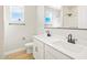 Bright bathroom featuring dual sinks, black fixtures, and wood-look tile flooring at 17731 W Elm St, Goodyear, AZ 85395