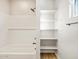 Bright bathroom featuring bathtub and storage shelving at 17731 W Elm St, Goodyear, AZ 85395