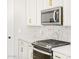 Close-up of kitchen features including stainless steel microwave, gas range, and marble backsplash at 17731 W Elm St, Goodyear, AZ 85395