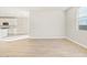 Bright living room with wood-look floors leading to kitchen with marble backsplash at 17731 W Elm St, Goodyear, AZ 85395