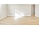 Bright, empty living room with wood-look tile floors and a window at 17731 W Elm St, Goodyear, AZ 85395