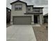 Two story home featuring a two car garage, and simple front yard landscaping at 1937 E Parr Fame Ln, San Tan Valley, AZ 85140