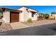 View of a stucco home with wood garage door and gravel landscaping at 26223 N Bravo Ln, Rio Verde, AZ 85263