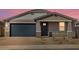 Charming single-story home with a well-manicured front yard and a blue garage door at 4820 N 177Th Dr, Goodyear, AZ 85395