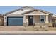 Charming single-story home with a well-manicured front yard and a blue garage door at 4820 N 177Th Dr, Goodyear, AZ 85395