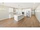 Bright, modern kitchen with stainless steel appliances, a large island, and wood-look tile flooring at 4820 N 177Th Dr, Goodyear, AZ 85395