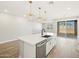 Kitchen island with white cabinets, stainless steel dishwasher, kitchen sink and lighting at 4820 N 177Th Dr, Goodyear, AZ 85395