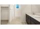 Bathroom featuring tile flooring, a single sink vanity, and a walk-in closet at 8657 W Warner St, Tolleson, AZ 85353