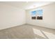 This bedroom features neutral carpet and a window bringing natural light into the space at 8657 W Warner St, Tolleson, AZ 85353