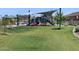 Community park featuring a playground under a shade cover, grass lawn, and neighborhood homes in background at 8657 W Warner St, Tolleson, AZ 85353