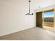 Dining area features a modern chandelier, sliding glass door to patio, and neutral ceramic tile at 8657 W Warner St, Tolleson, AZ 85353