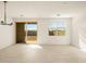 Bright living room with tile flooring, a modern light fixture and sliding glass doors to the backyard at 8657 W Warner St, Tolleson, AZ 85353