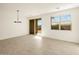 Open living room with sliding glass door, window with blinds, and ceramic tile flooring at 8657 W Warner St, Tolleson, AZ 85353