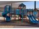 A close view of the community playground with colorful blue and red play equipment with wood chip base at 8657 W Warner St, Tolleson, AZ 85353