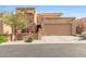 Tan stucco exterior of a two-story home with a double garage and landscaped front at 10653 N 10Th Pl, Phoenix, AZ 85020