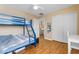 Bright bedroom with a bunk bed, built-in shelving, and wood flooring at 22821 S 212Th St, Queen Creek, AZ 85142