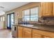 Kitchen features light wood cabinets, granite counters, and a view to backyard at 22821 S 212Th St, Queen Creek, AZ 85142
