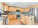 Kitchen boasts light wood cabinets, granite counters and stainless steel appliances at 22821 S 212Th St, Queen Creek, AZ 85142